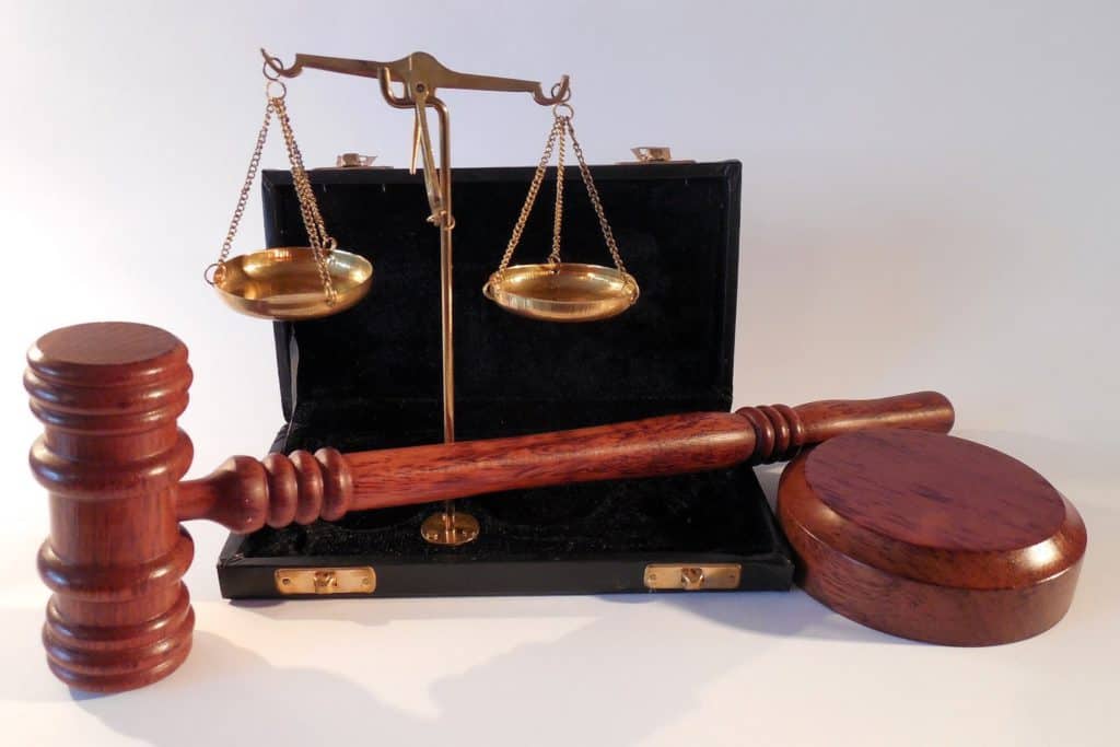 wooden gavel and bronze scales of justice